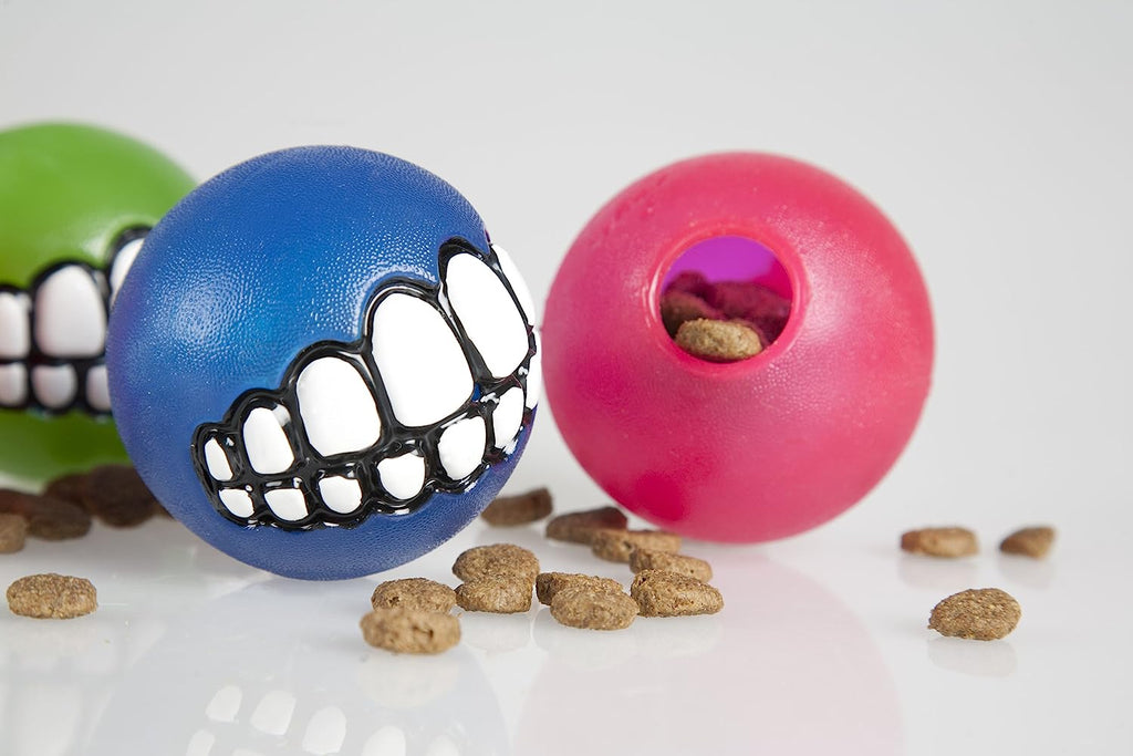 Rogz Grinz Treat Ball Pink displayed alongside other colorful treat balls, highlighting its unique design.